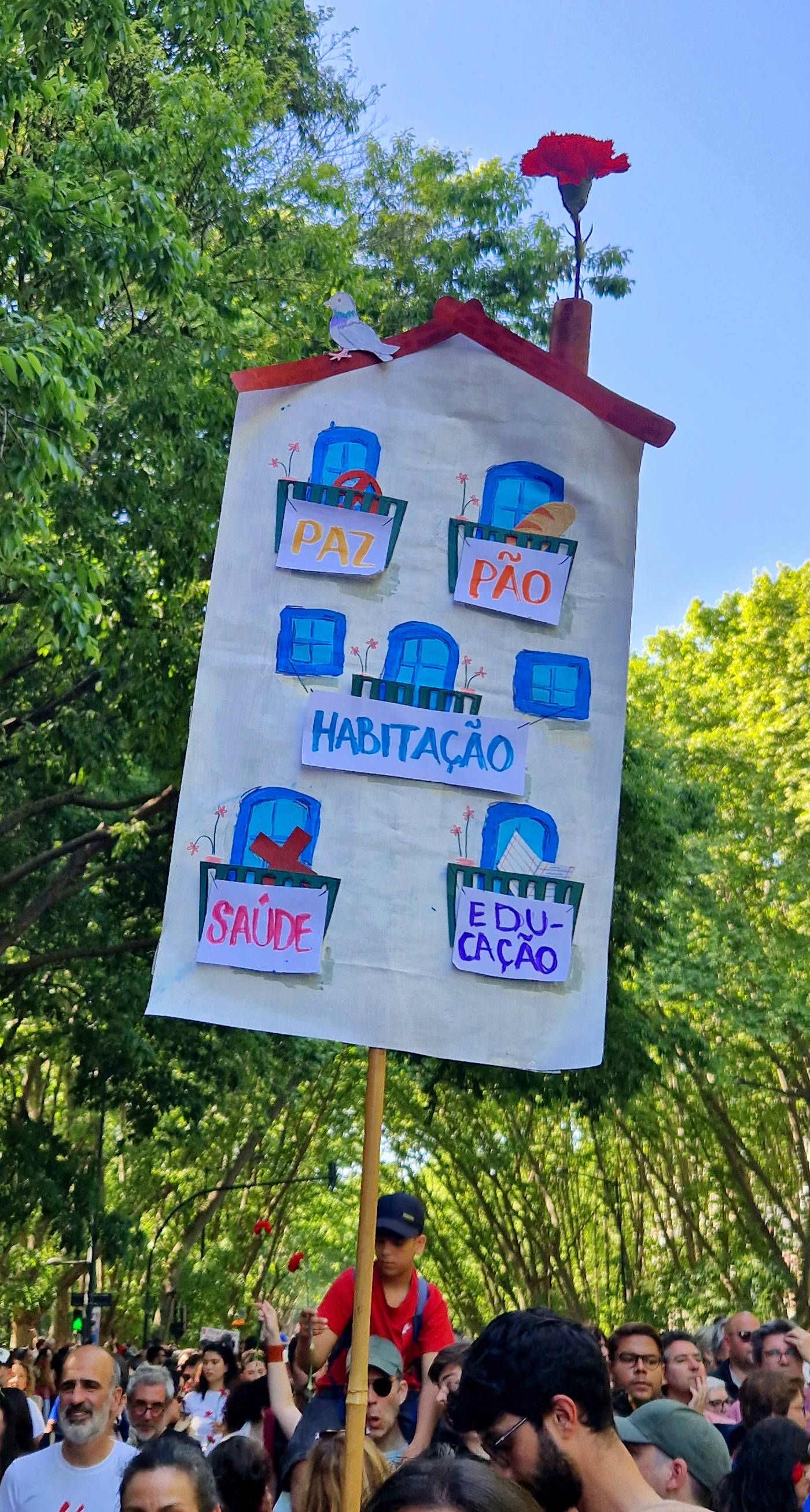 Um cartaz rebuscado com 5 janelas com coisas, "a paz, pão, habitação, saúde, educaçao"